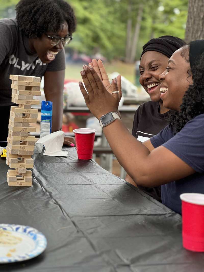 Church members laughing over a game at a summer cookout