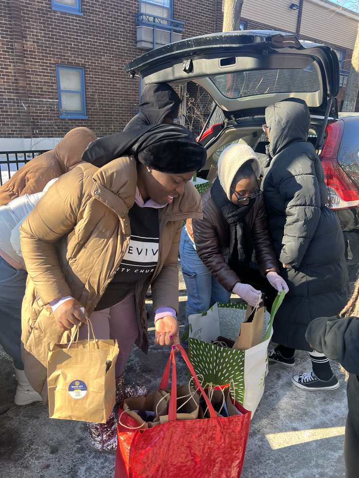 Volunteers loading care packages into a car